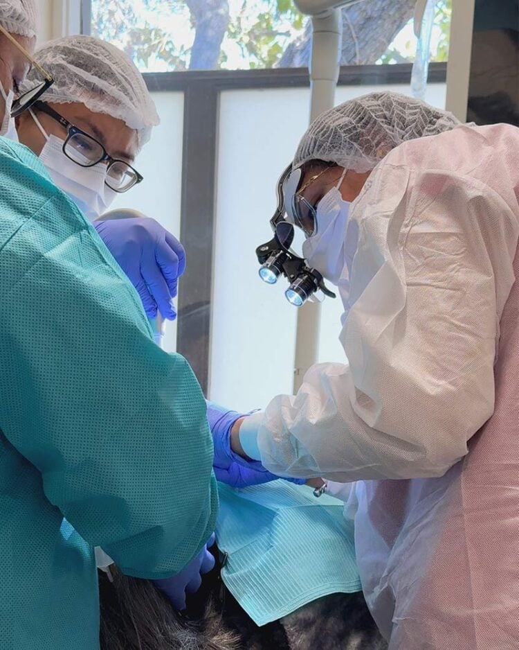 Dr. Sheoran wearing magnification loupes and protective equipment during an implant procedure