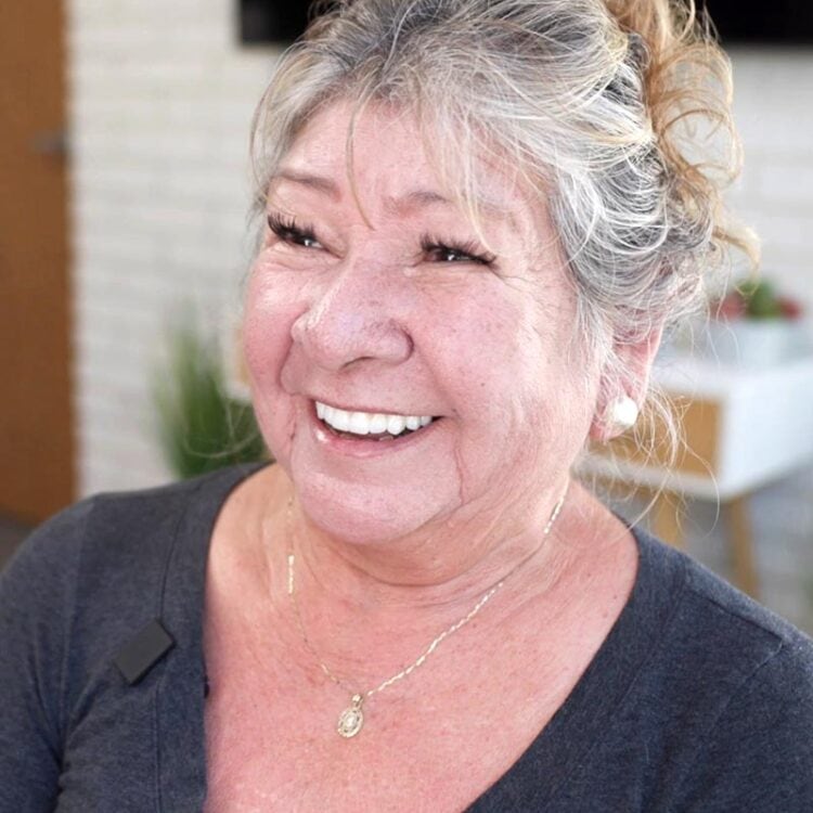 Happy dental implant patient laughing and showing her restored smile