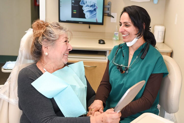 Happy patient seated in the dental chair with Dr. Sheoran at Mai Dental Care