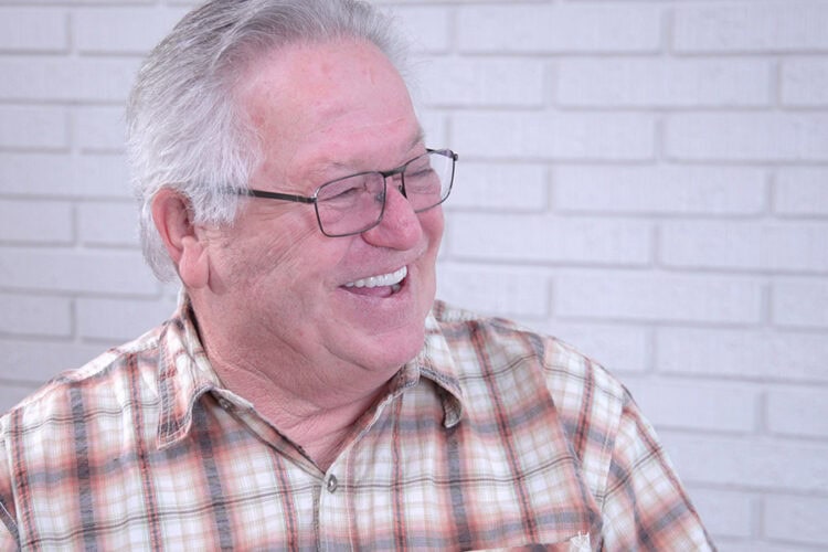 Happy male patient showing his restored smile after dental implant treatment